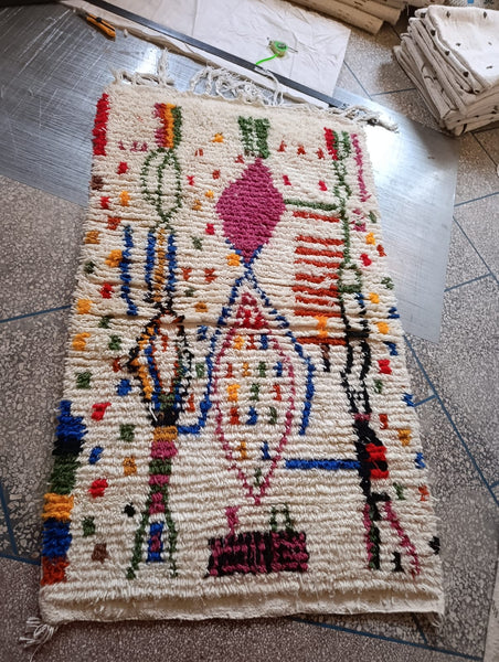 Handwoven Moroccan Azilal rug — workshop view, ivory and multicolour