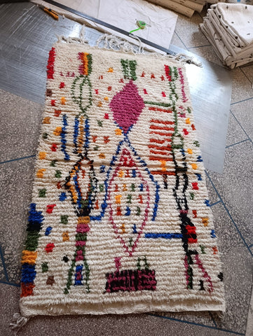Handwoven Moroccan Azilal rug — workshop view, ivory and multicolour