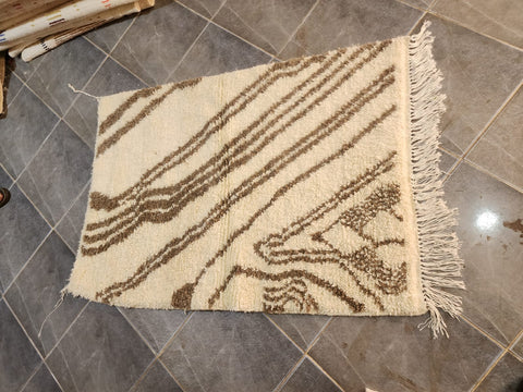 Handwoven Moroccan Azilal rug — workshop view, ivory and brown abstract
