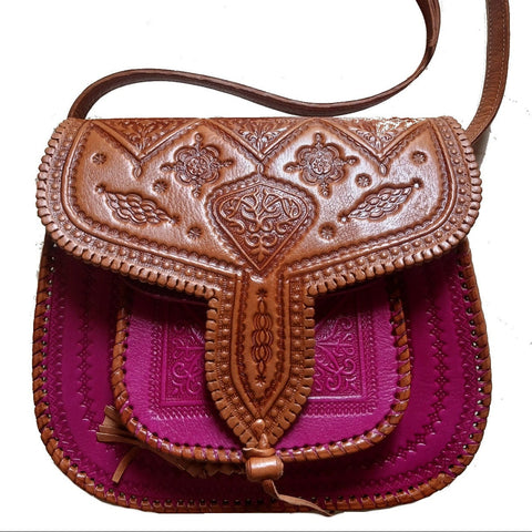 Brown leather handbag with intricate designs on a white background