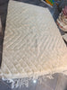 Handwoven Moroccan ivory wool rug — chevron pattern in relief, workshop view