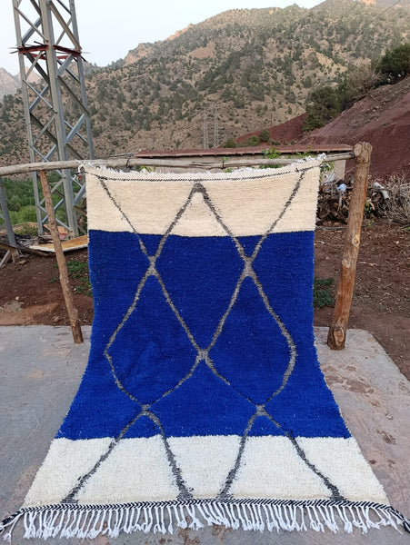 Izri — The Unbroken Line, handwoven Moroccan Beni Ourain rug in ivory and cobalt blue, High Atlas, 227x152cm