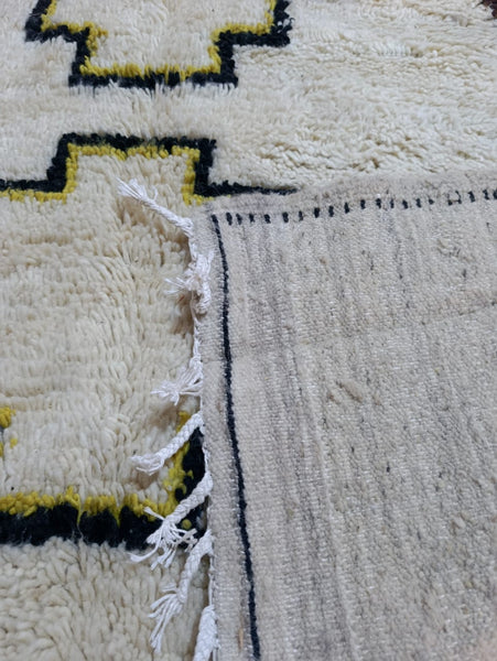 Detail of the singular black dot — the beauty mark — woven into the central medallion