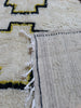 Detail of the singular black dot — the beauty mark — woven into the central medallion