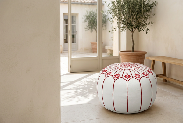 Hero du pouf blanc à broderies rouges dans un jardin d’hiver