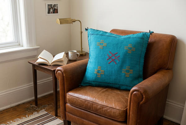 Lalla Zineb turquoise pillow on a cognac leather reading chair