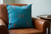 Mizan turquoise pillow on a cognac leather reading chair