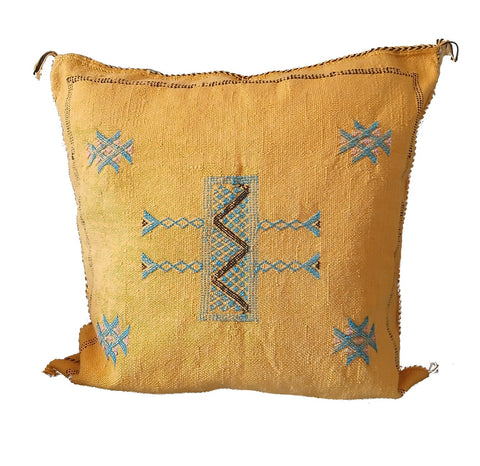 Yellow pillow with blue and brown geometric patterns on a white background