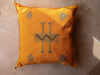 Yellow pillow with decorative patterns on a textured surface