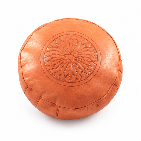 Pouf marocain orange rond embossé, photographie éditoriale sur fond blanc