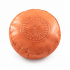 Pouf marocain orange rond embossé, photographie éditoriale sur fond blanc