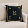 Sidi Omar Black pillow on an ivory linen armchair in soft natural daylight